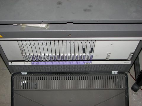 Geöffnete Telefonanlage mit einer Reihe von Steckkarten und Statusleuchten