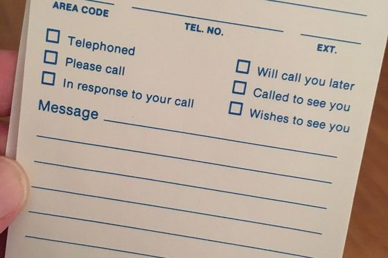 Hand hält einen leeren Telefonnotizblock „Memo of Call“ mit Feldern und Ankreuzkästchen